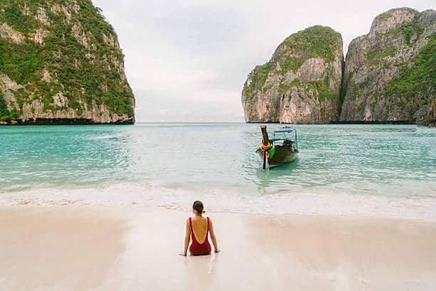 Young Caucasian woman sitting on Maya Bay beach in Krabi, Thailand